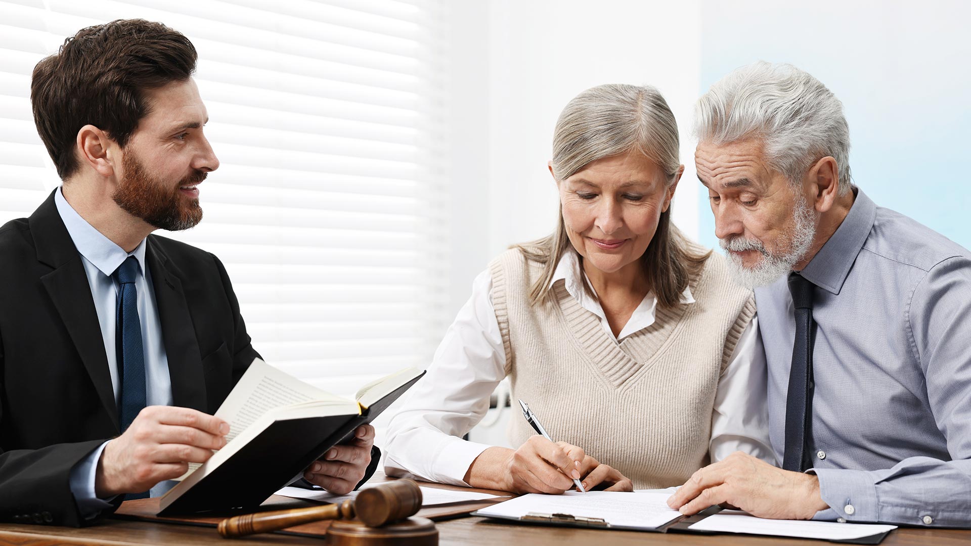 lawyer meeting with married baby boomer couple to sign will documents